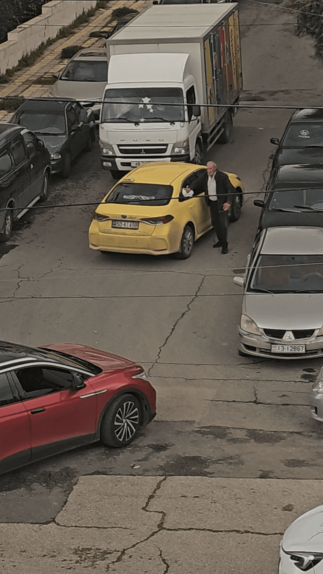 فن اختيار الوقت.. سائق تاكسي ينظّف مركبته من الغبار وسط الشارع ويتسبب في أزمة خانقة