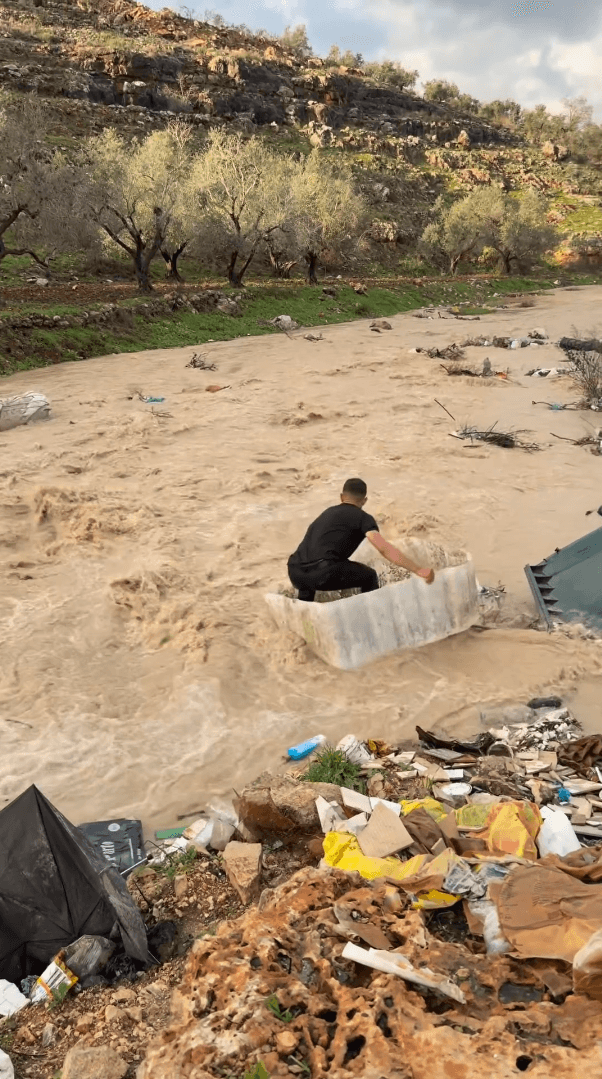 فلسطيني يستغل سيول الأمطار لممارسة رياضة ركوب الأمواج