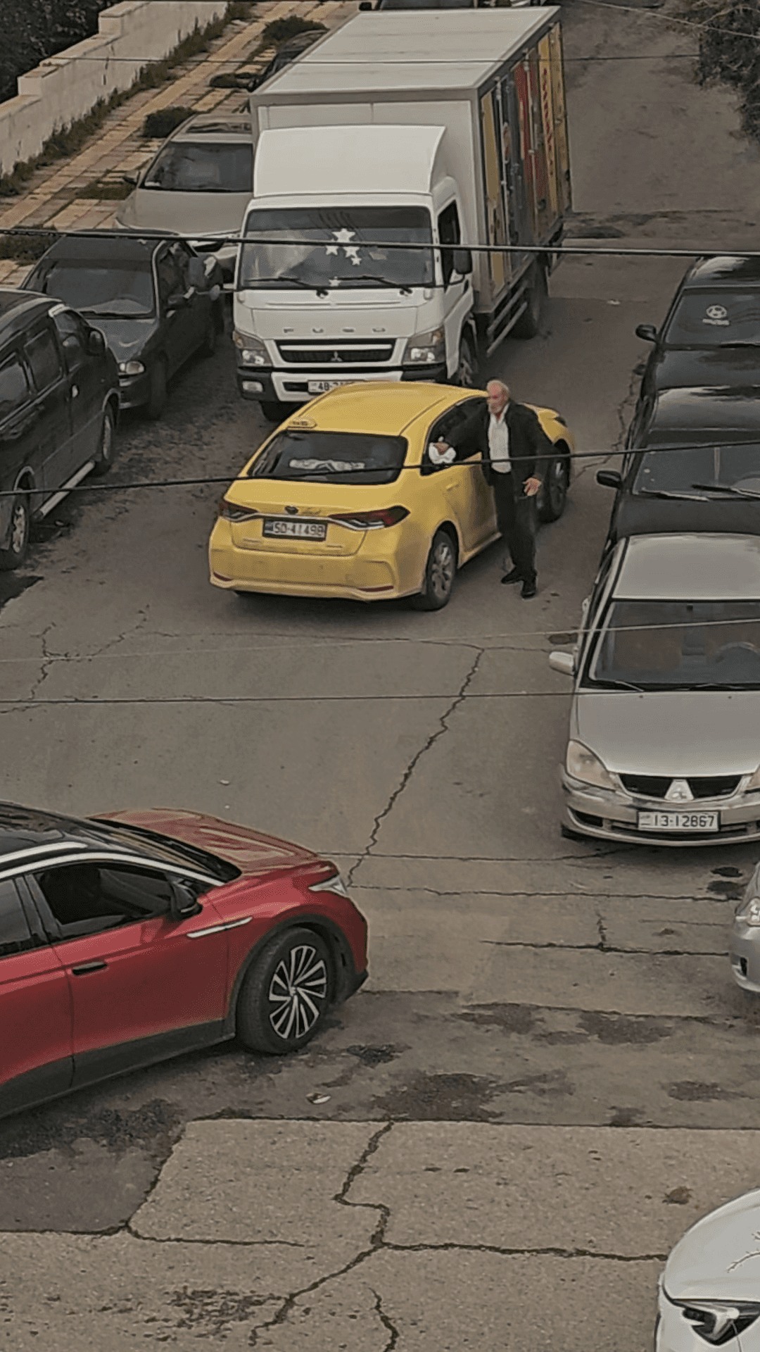 فن اختيار الوقت.. سائق تاكسي ينظّف مركبته من الغبار وسط الشارع ويتسبب